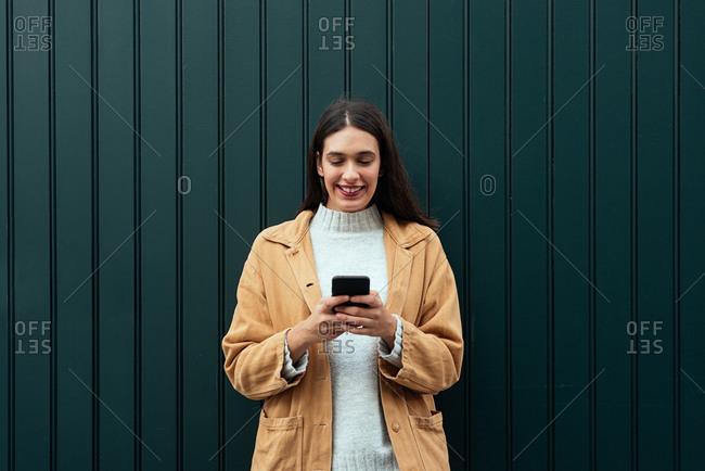 Woman standing on the street and using her smartphone