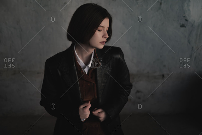 Young woman in leather jacket, low key portrait, grunge background