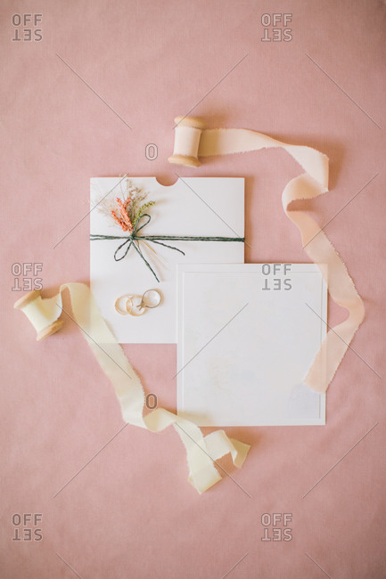 Wedding invitation on pink backdrop.