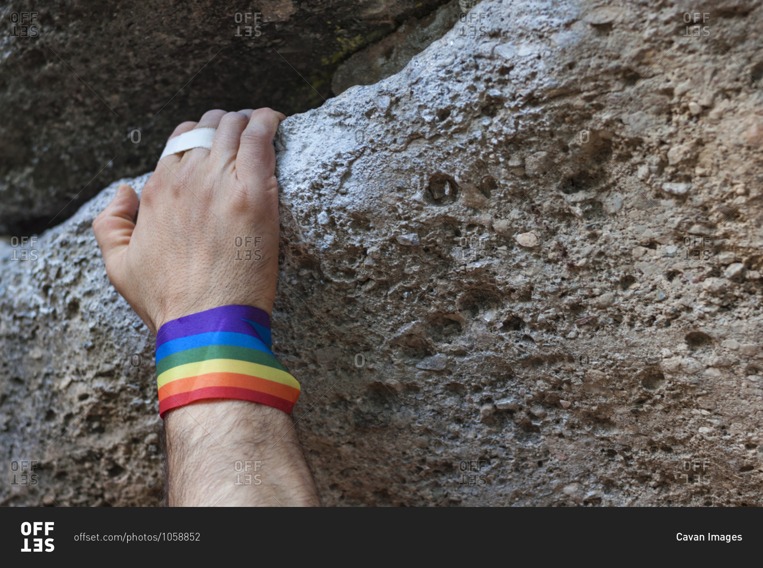 Climbing hand with gay pride bracelet