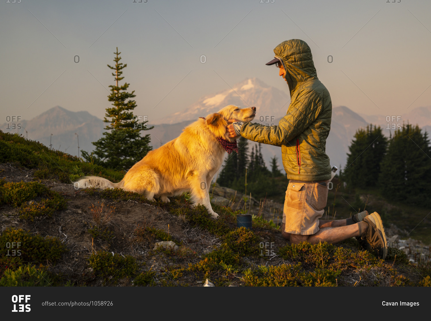 Dog getting pets and scratches as the sun sets in the alpine