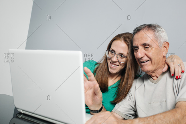 Cheerful couple having video conversation via laptop