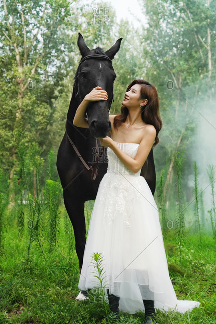 Wear the wedding dress beautiful women hug horse