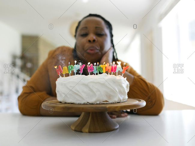 Kids birthday party. Boy blowing out candles on cake Stock Photo by  Prostock-studio