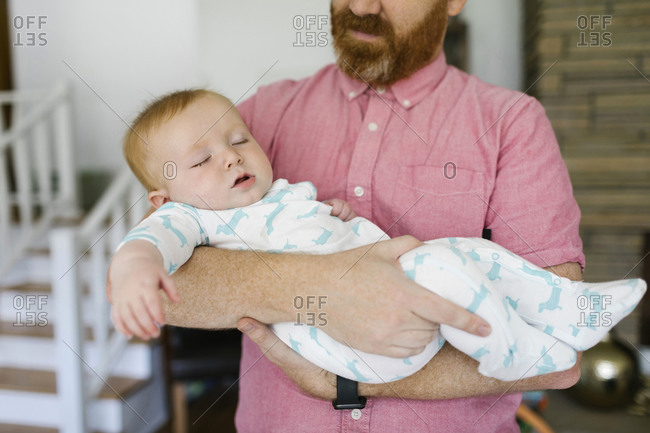 Father carrying sleeping baby son (6-11 months )