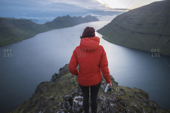Denmark, Faroe Islands, Gjgv, Woman standing on Klakkur mountain and looking at fjord