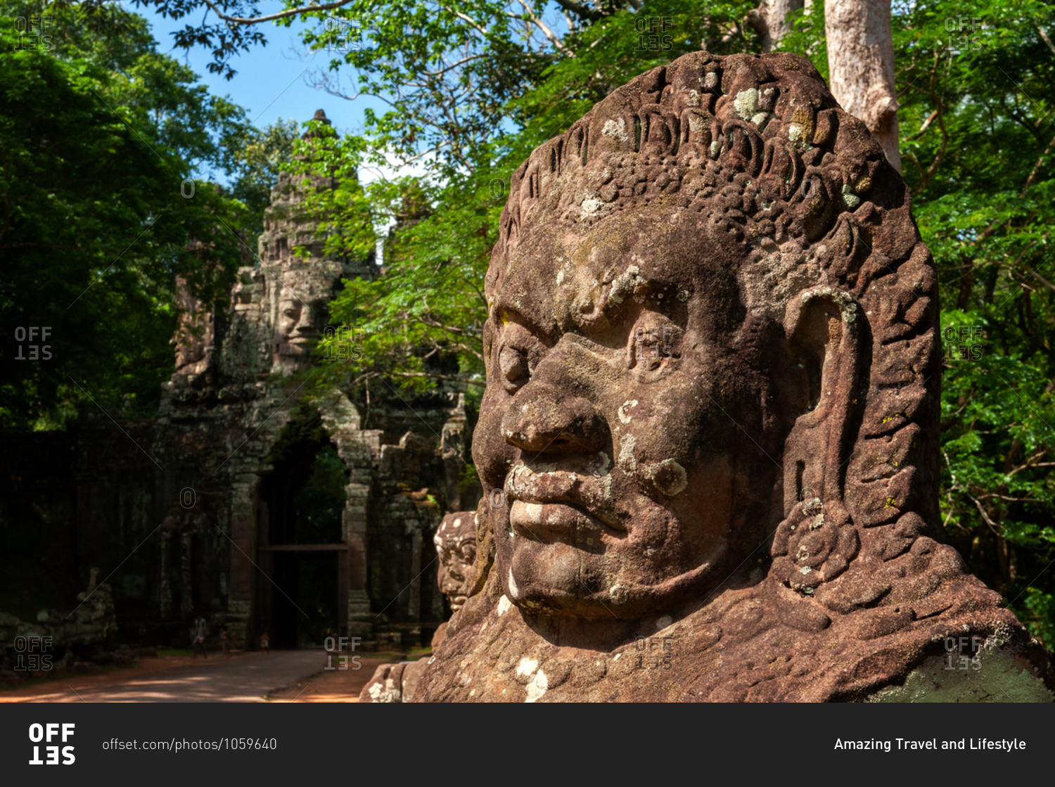 Ancient carved faces on south gate of Angkor Thom. Bad gods in hindu epic tale of a tug of war between good vs evil in the story the churning of the sea of milk.
