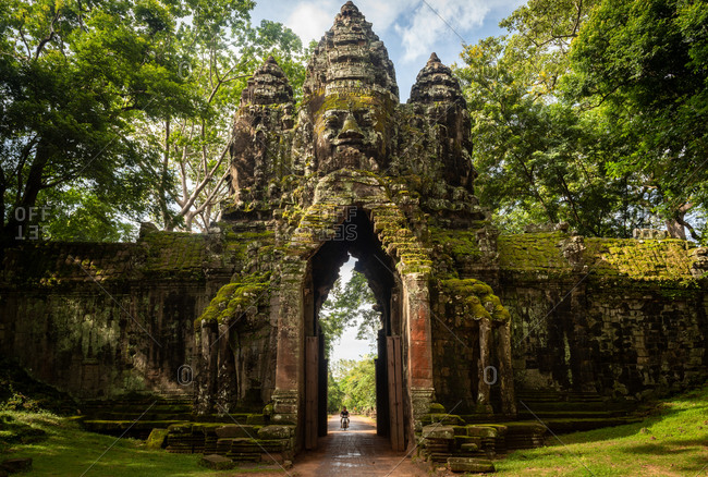 Angkor Archaeological Park, Siem Reap, Cambodia. Single motor bike passing through north gate of Angkor Thom.
