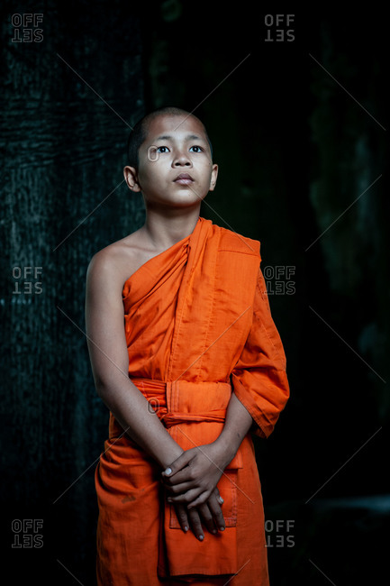 SIEM REAP, CAMBODIA - 21 January 2014: Monk looks towards the light at north gate of Angkor Wat.