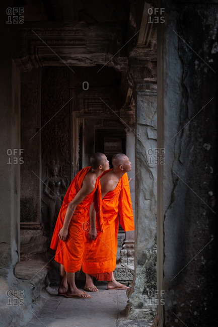 SIEM REAP, CAMBODIA - 30 JULY 2010: Monk in Angkor Wat gallery looking into courtyard.