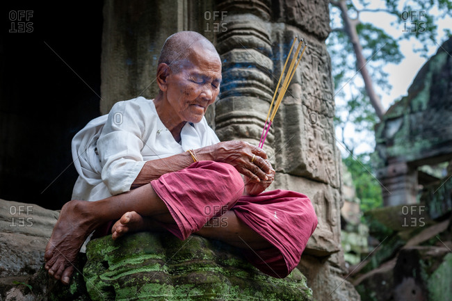 SIEM REAP, CAMBODIA - 08 July 2012: Nun praying at Preah Khan Temple, Angkor Park.