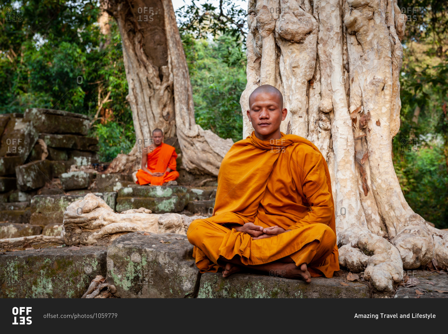 SIEM REAP, CAMBODIA - 19 January 2011:  Monks meditate amongst trees Angkor Park.