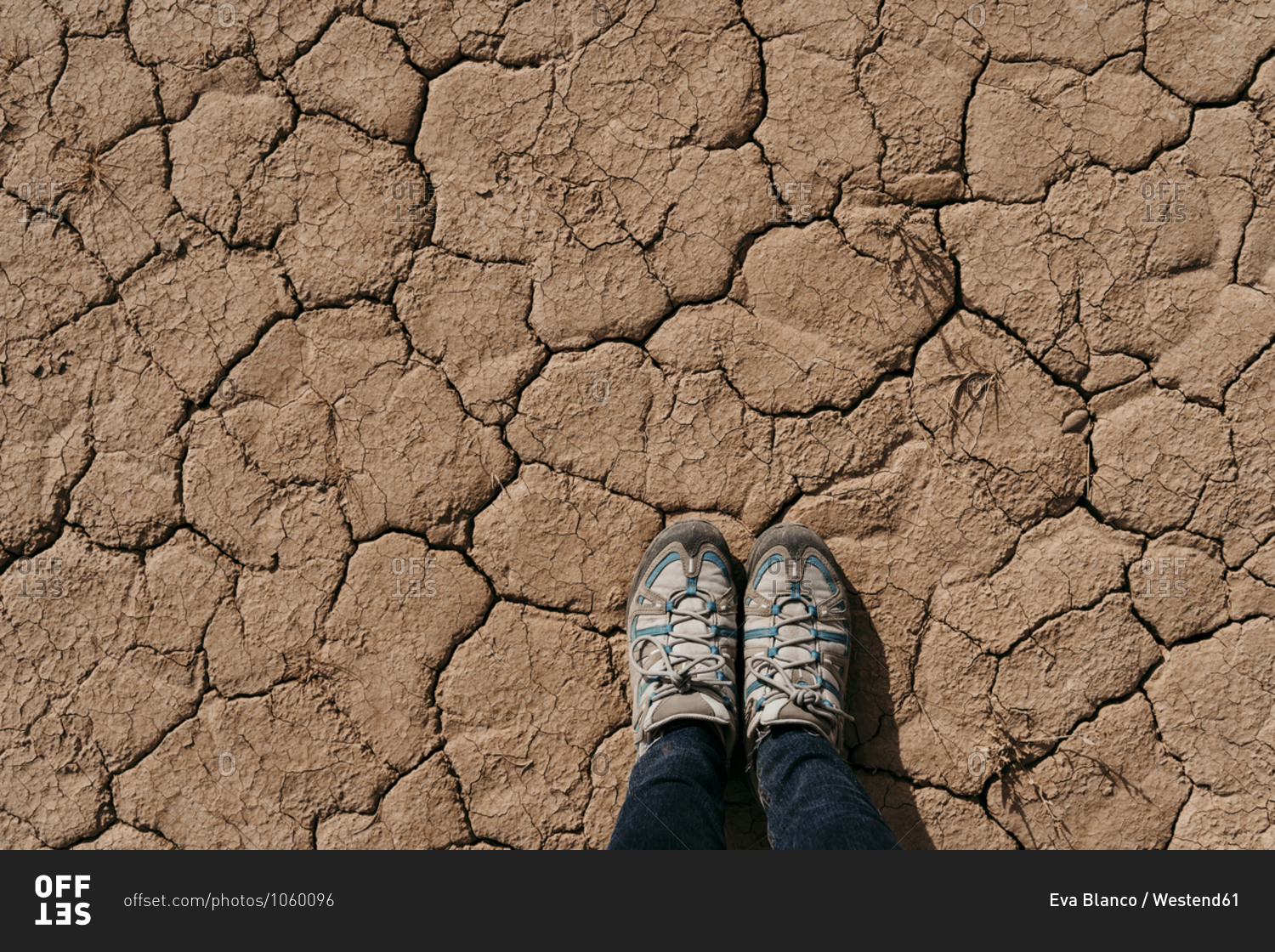 Spain- Navarre- Shoes of woman standing on dry cracked ground of Bardenas Reales