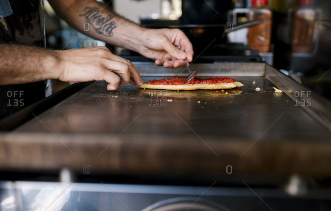 Male chef preparing tomato sandwich in coffee shop