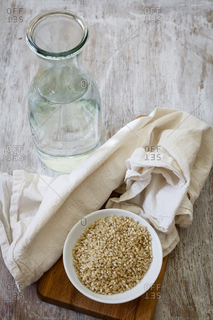 Ingredients for making rice milk - bottle of water- fabric and bowl of brown rice