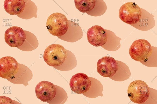 Ripe pomegranates arranged on beige background