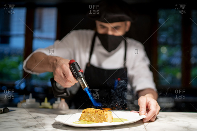 Chef preparing pudding while giving flame in restaurant kitchen