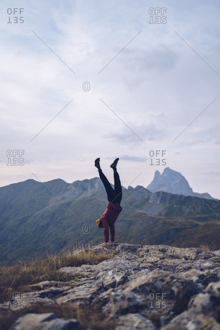 Young man doing handstand on mountain around Ibones of Anayet