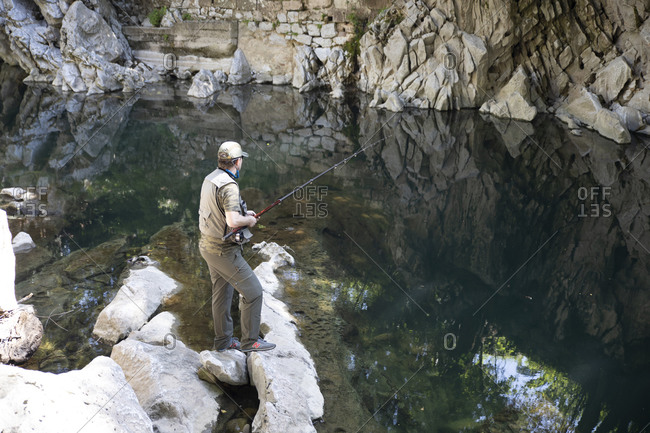 Spain, Cantabria, Puente Viesgo - May 29, 2020: fisherman fishing salmons in north spain