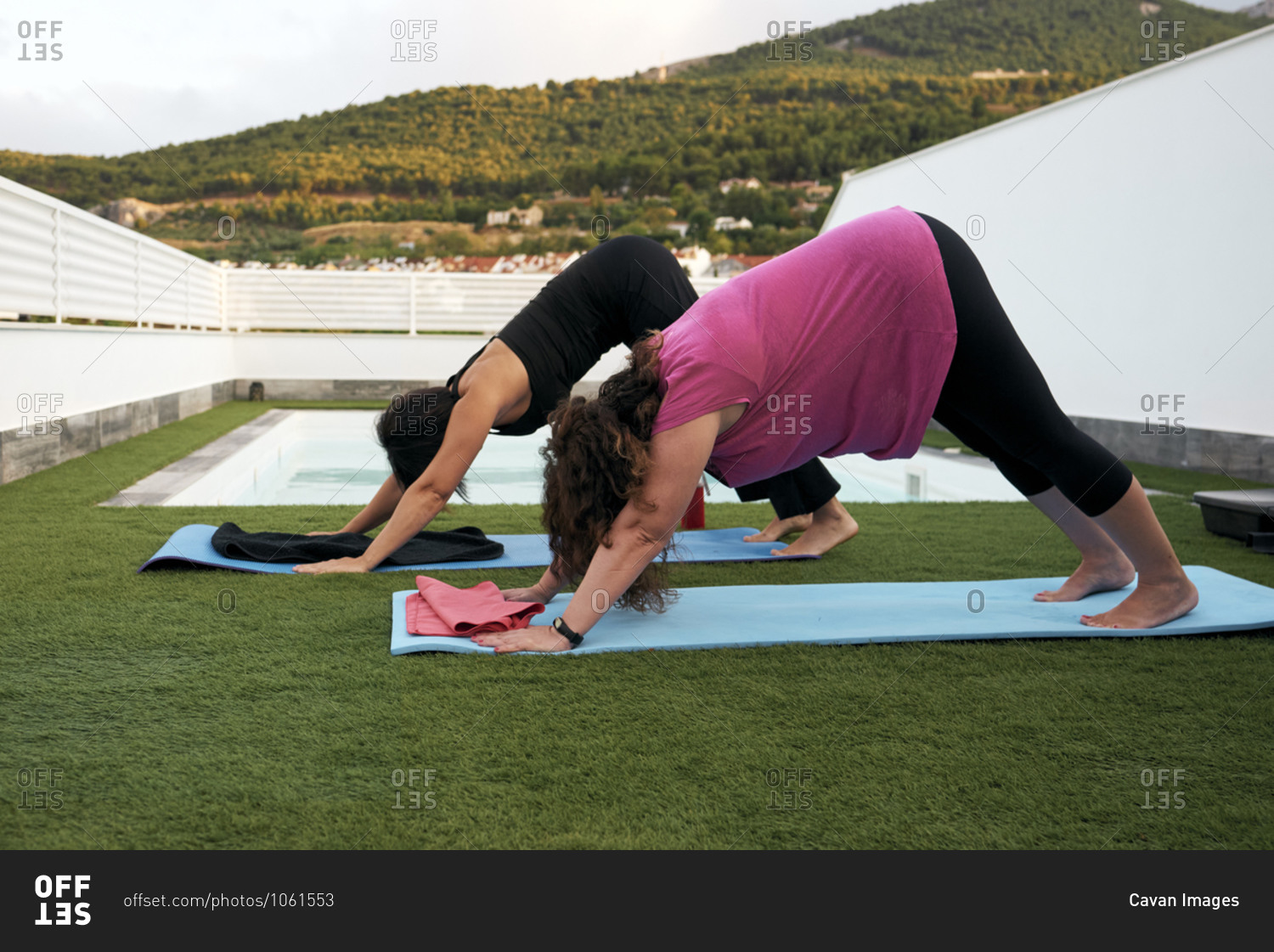 Women do yoga on the terrace of the house, face down dog posture