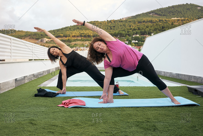 Women do yoga on the terrace of the house, triangle posture