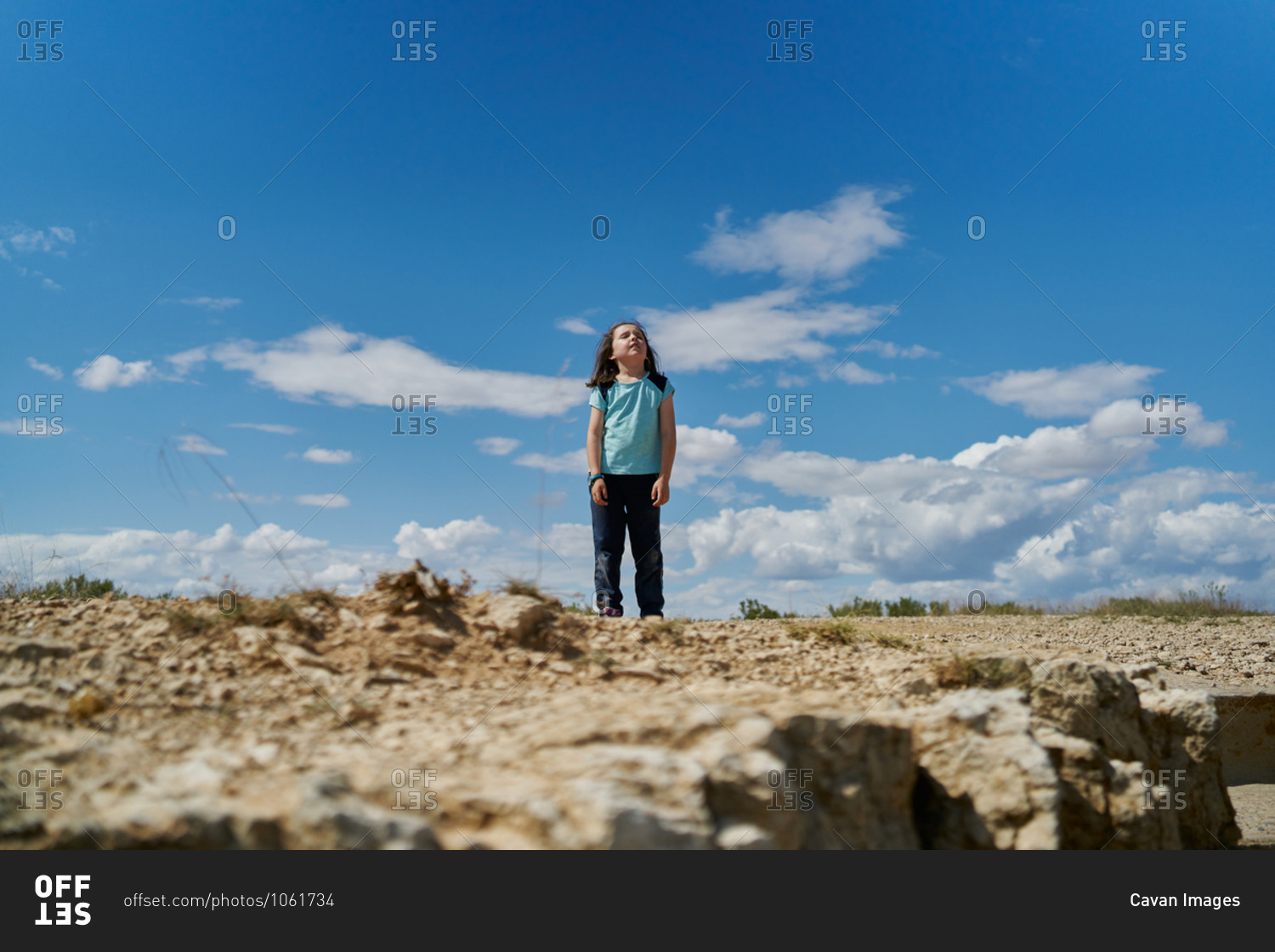 Girl wearing a blue blouse posing in the Bardenas Reales national park in Navarra, Spain. Tourism concept
