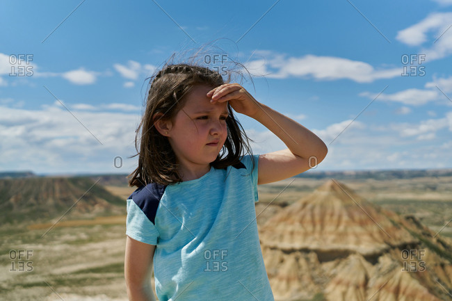 Girl wearing a blue blouse posing in the Bardenas Reales national park in Navarra, Spain. Tourism concept
