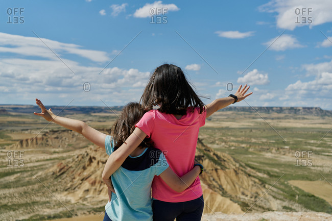 Little sisters in viewpoint observing a desert mountain in the Bardenas Reales national park in Navarra, Spain. Travel concept
