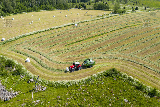 Tractor collecting hay on field