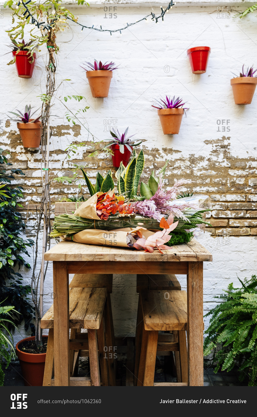 Wooden table at floristry workshop full of flowers for arrangements