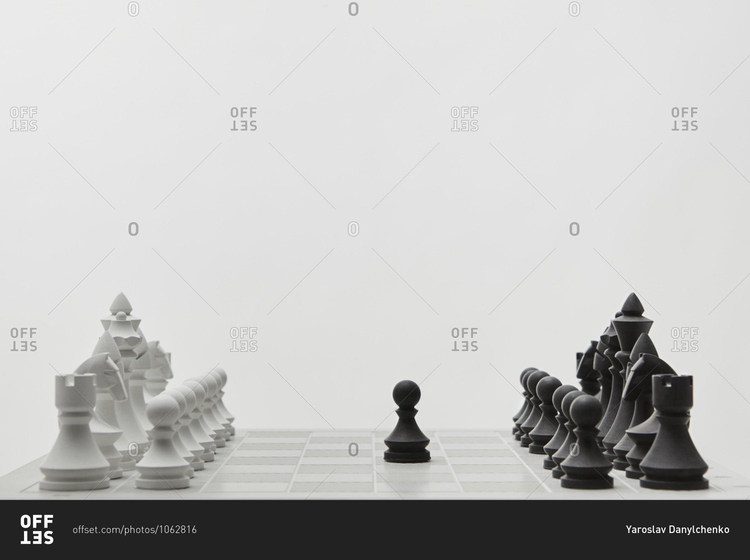 Chessboard with lined up white and black figures.