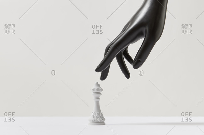 Woman Hand Holding a White Queen Piece Over a Chess Board