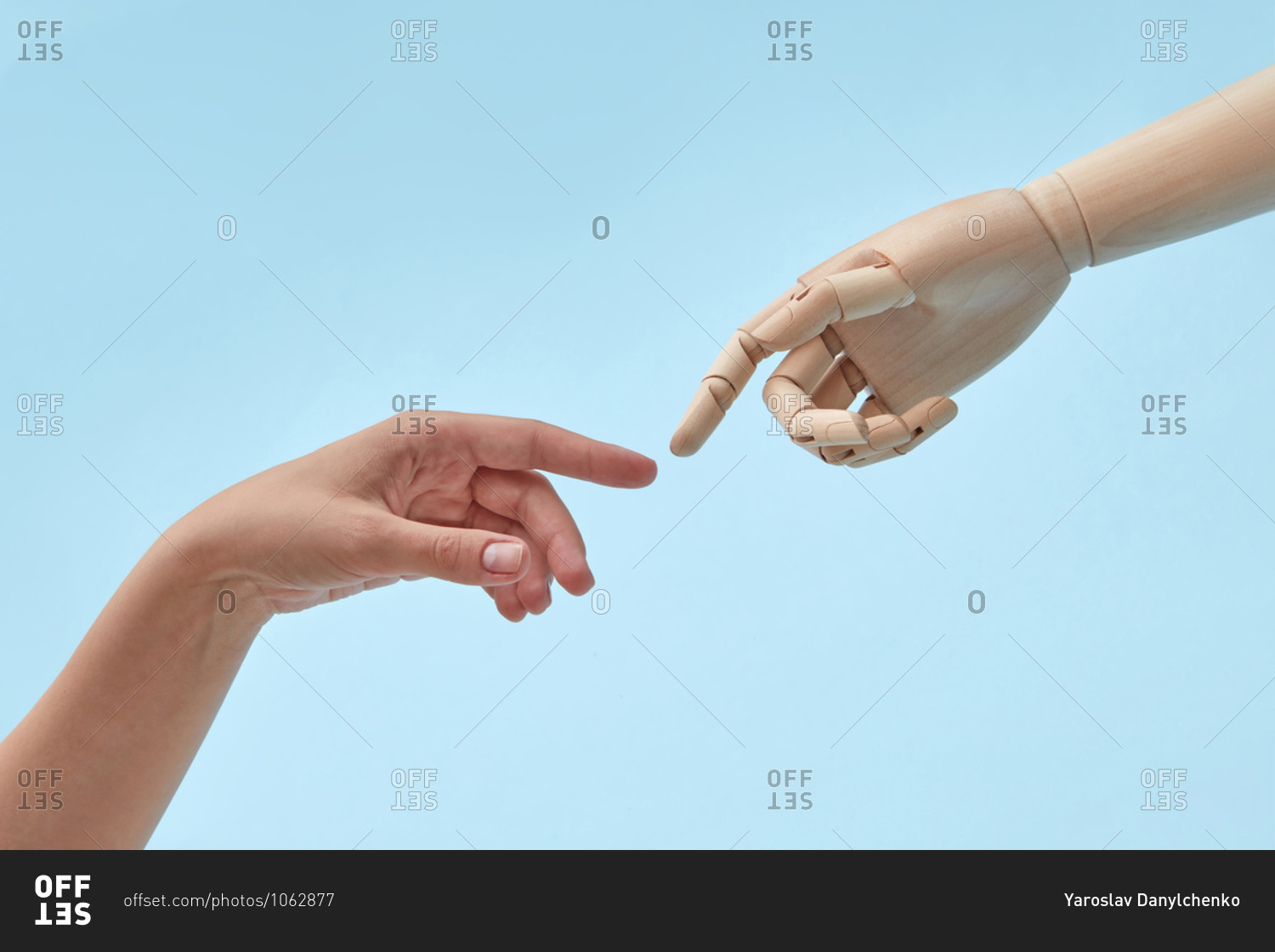 Woman and doll hands with almost touching fingers.