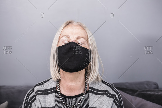 Elderly woman wearing a black facemask during a pandemic