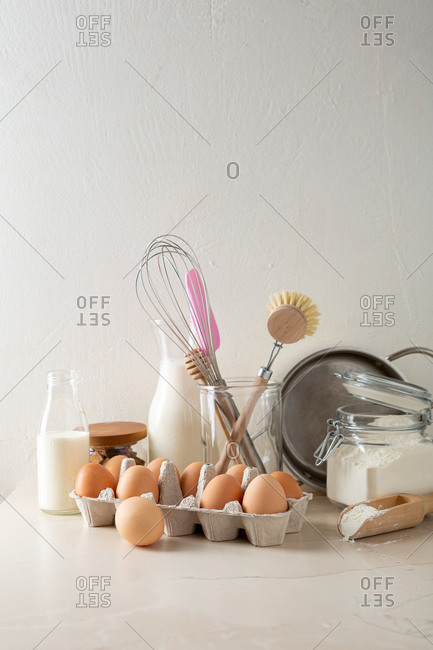Utensils and ingredients on kitchen counter for preparing custard cream