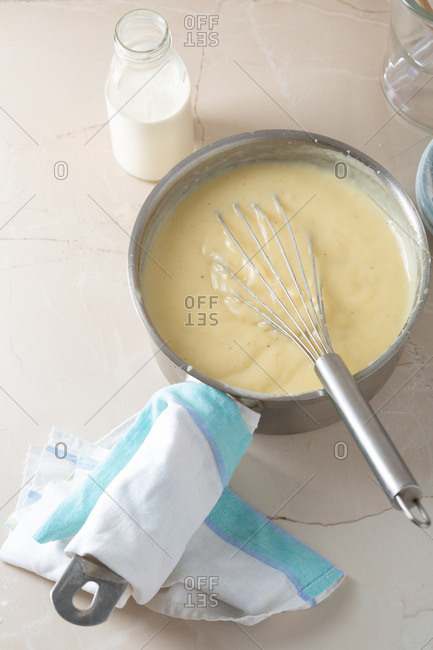 Vanilla custard in saucepan on light surface
