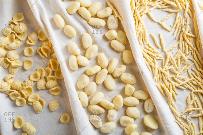 Overhead view of raw homemade pasta on white linen cloth