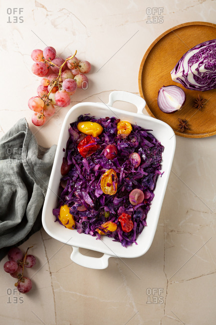 Roasted red cabbage in a baking dish with tomatoes and grapes