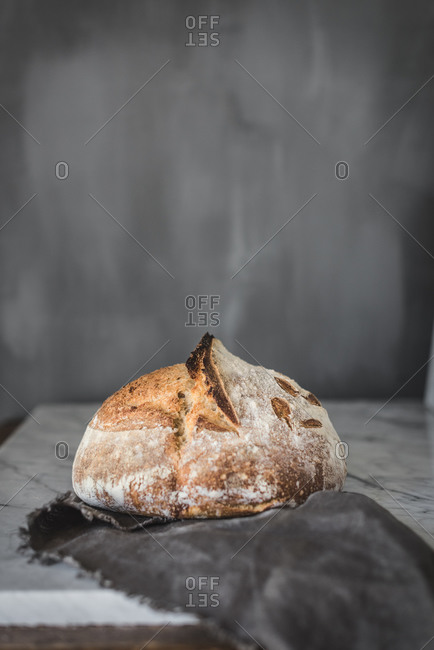 From above of yummy fresh baked bread with crispy crust placed on marble table in modern kitchen
