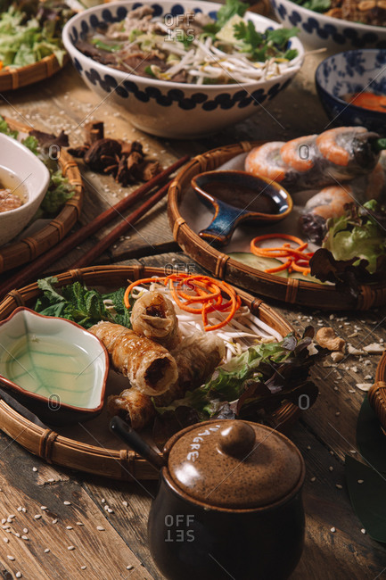 From above of assorted dishes of Vietnamese cuisine arranged on wooden table in luxury restaurant