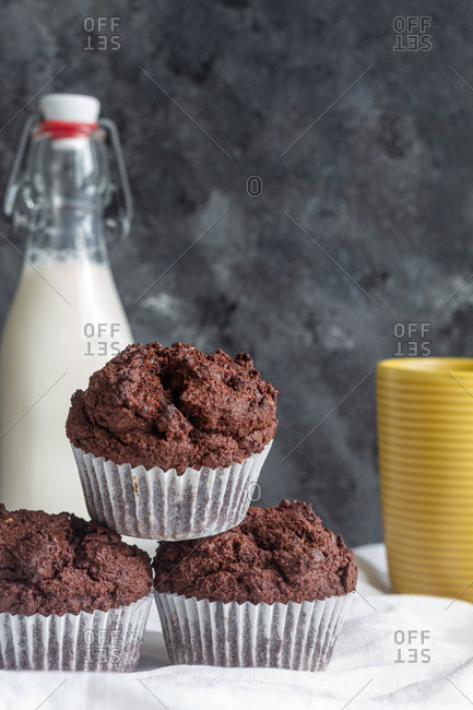 Delicious homemade chocolate muffins heaped on table in light kitchen