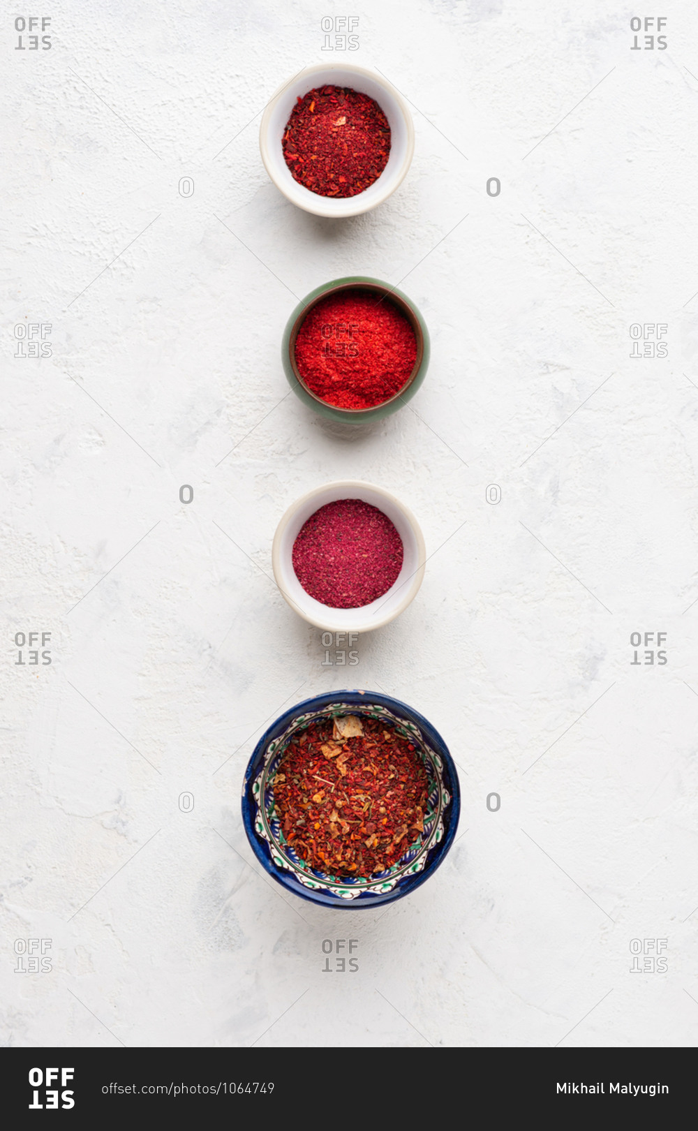 Overhead view of assorted red spices and ingredients over white background