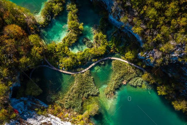 Aerial view of a wooden walkway surrounded by turquoise water in Lower Lakes, Korana, Croatia