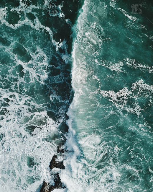 Aerial view of a huge breaking wave in the middle of the Atlantic ocean in Portugal.