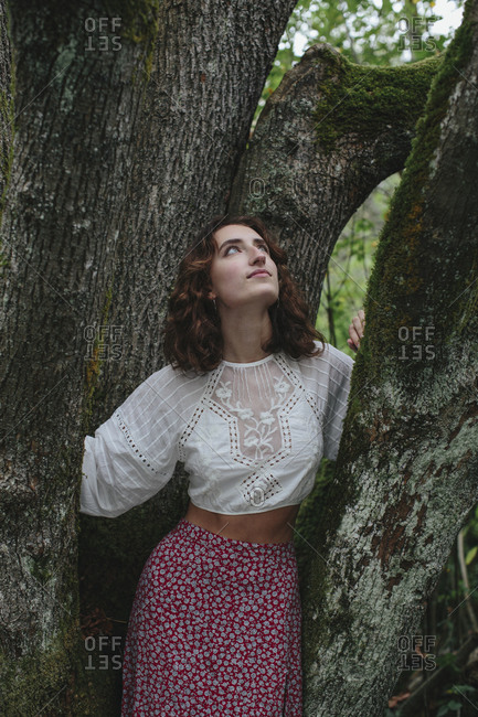Portrait of seventeen year old girl standing in front of mossy Bigleaf maple tree