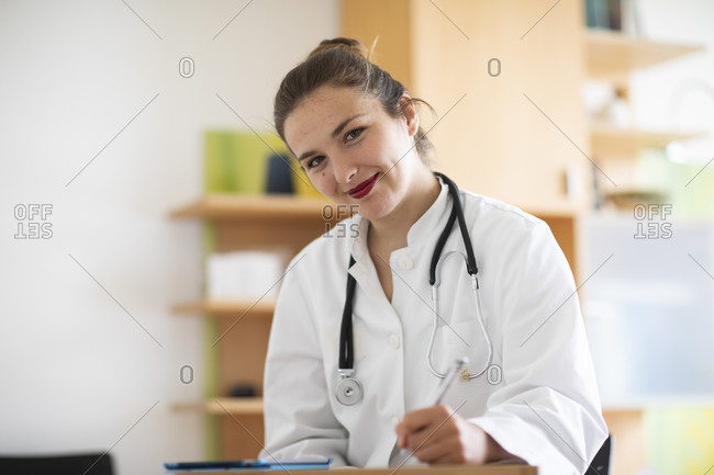 Doctor taking notes and smiling