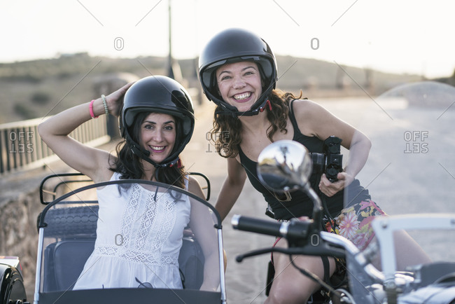 Pretty women on sidecar bike smiling and looking at camera