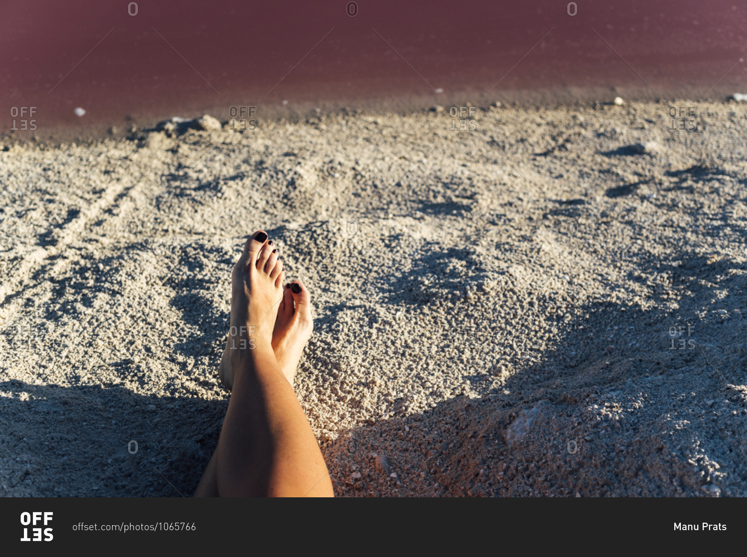 Crop legs of barefoot female on blurred background of pink lake in Las Coloradas, Mexico