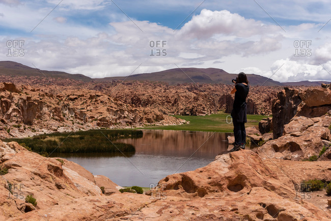 Woman taking a photo of a scenic landscape in the southwest of the Bolivian altiplano
