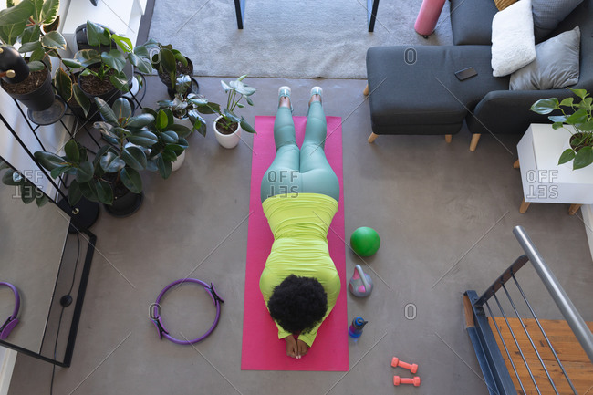 Overhead view of african american woman lying on exercise mat working out